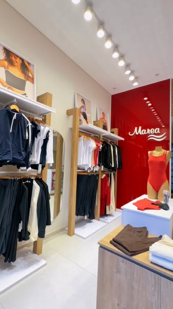 Interior real de un local Marea con pared roja, exhibición y mobiliario de madera clara
